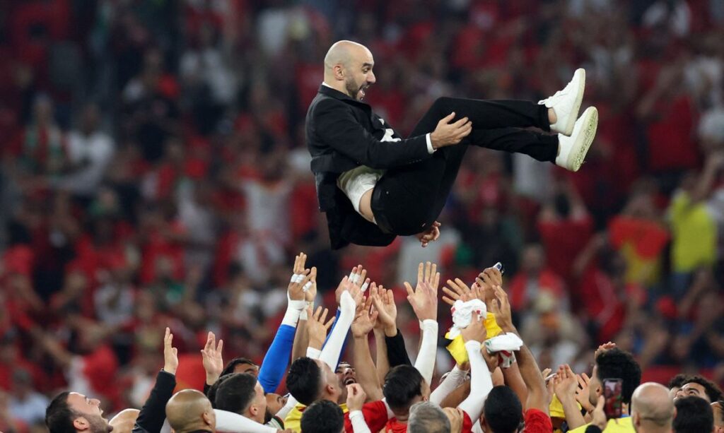 Marroquinos celebram a classificação jogando o técnico Walid Regragui para o alto (REUTERS).